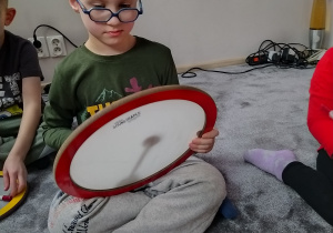 Chłopiec gra na dużym krążku dźwiękowym.